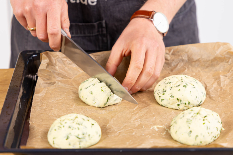 Teiglinge kreuzweise einschneiden und backen