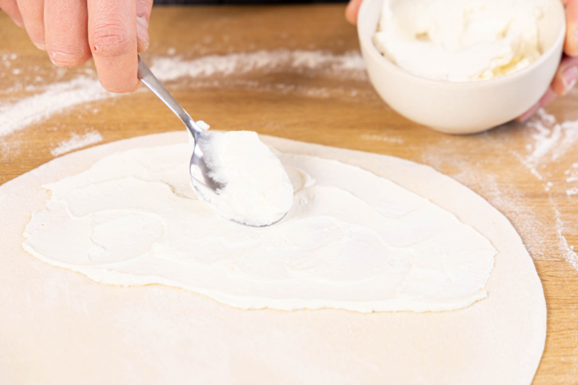 Ricotta auf dem Pizzaboden verstreichen