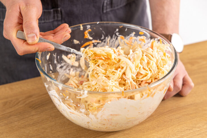 Dressing und Salat vermengen