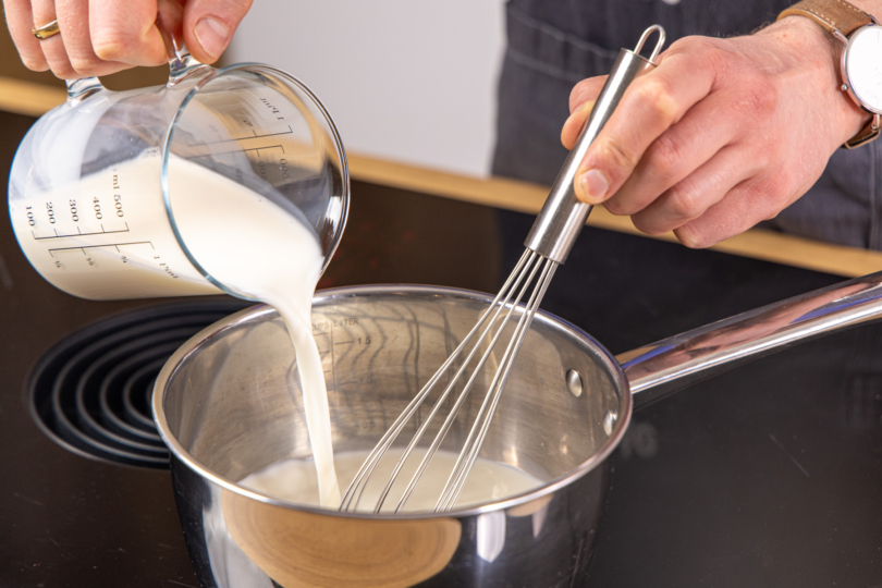 Milch in den Topf gießen