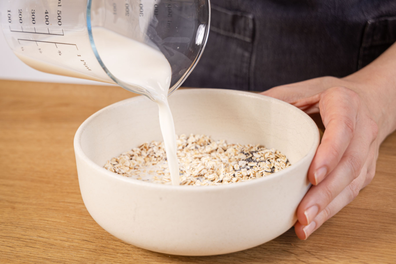 Milch zu den Haferflocken geben