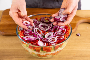 Zwiebelringe auf Salat verteilen