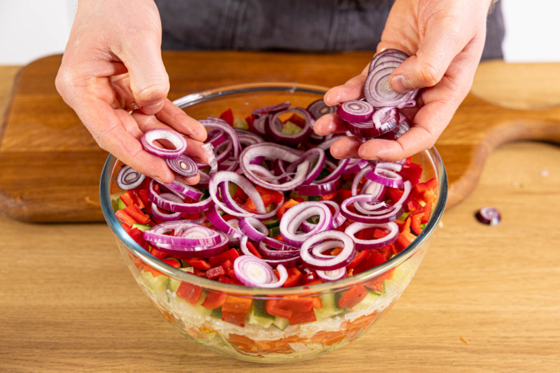 Zwiebelringe auf Salat verteilen