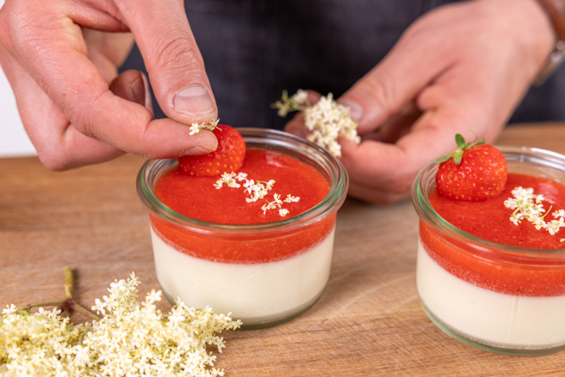 Holunder Panna Cotta mit Erdbeeren und Holunderblüten dekorieren