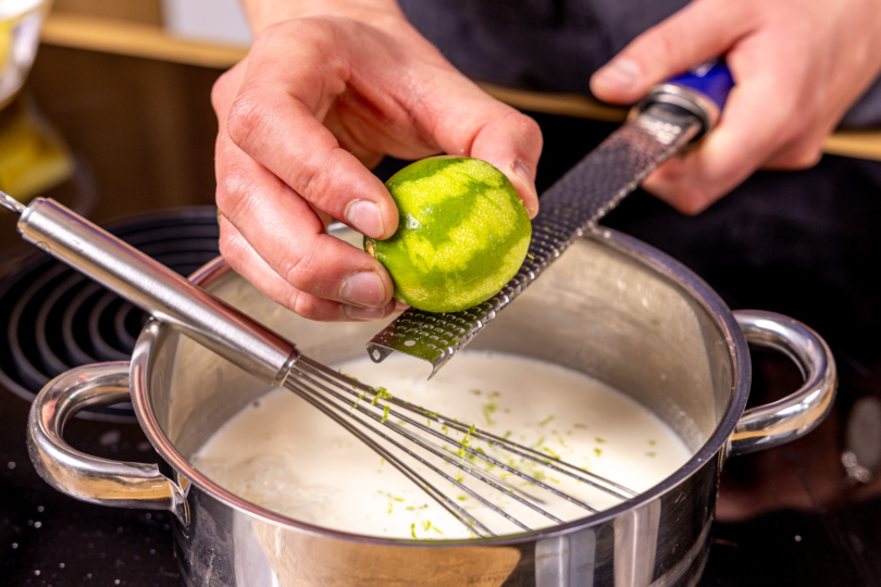 Limettenschale zur Panna-Cotta-Masse reiben