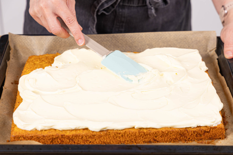 Frosting auf dem Rüblikuchen verstreichen