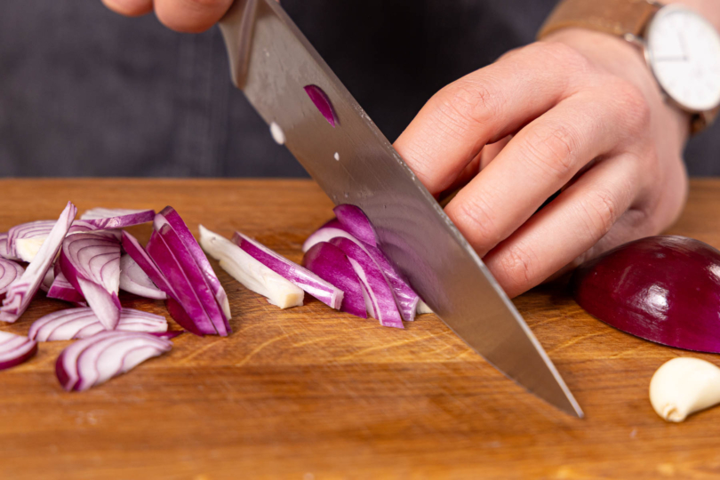 Zwiebel und Knoblauch in Streifen schneiden