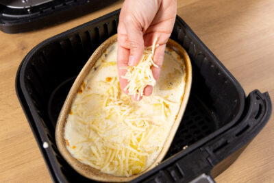 Kartoffelgratin mit Käse bestreuen