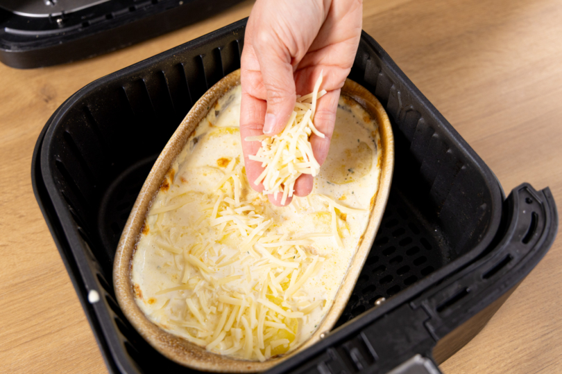 Kartoffelgratin mit Käse bestreuen