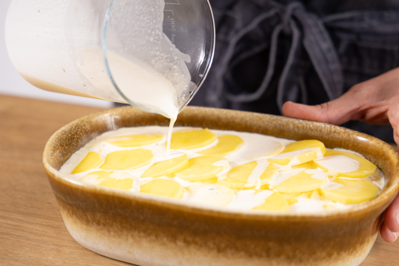 Sahne auf das Gratin geben