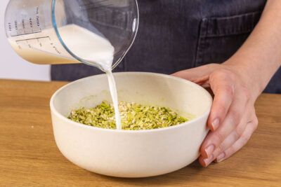 Milch zum Matcha Overnight Oats hinzu gießen
