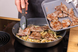 Fleisch zu den Zwiebeln geben