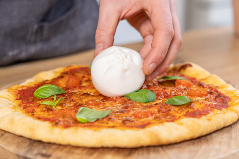 Burrata auf die Pizza legen