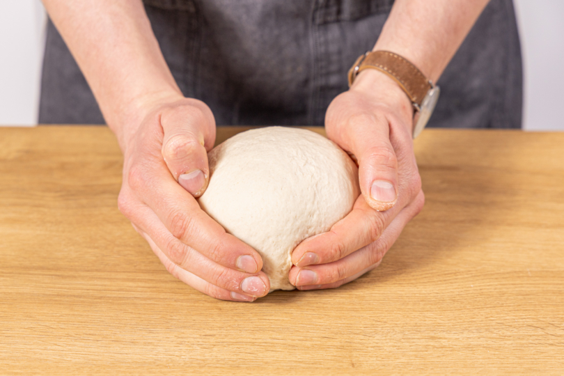 Teig zu einer glatten Kugel formen und auf Spannung bringen