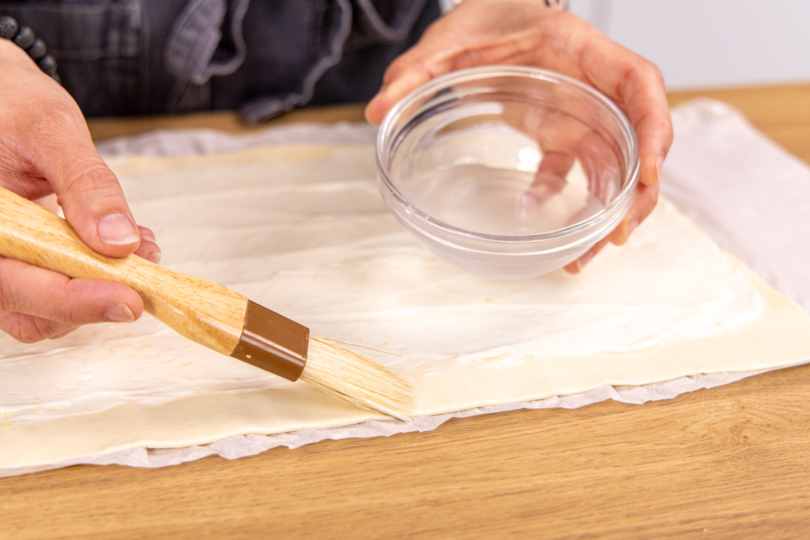 Teigrand mit Wasser bestreichen
