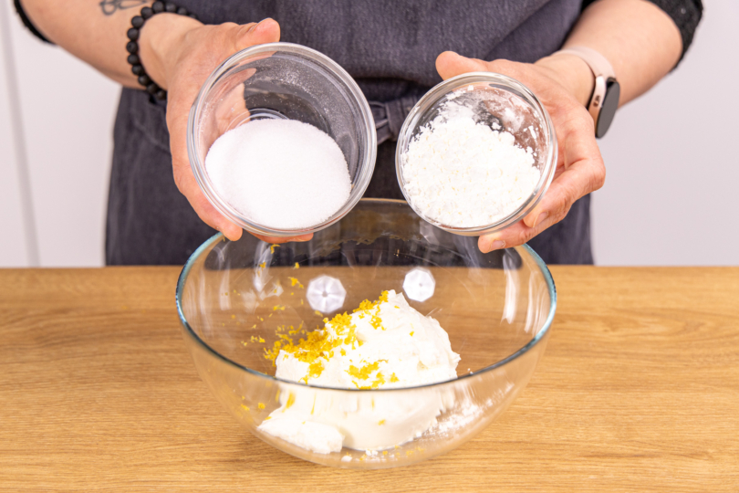 Zucker und Speisestärke zu dem Quark geben