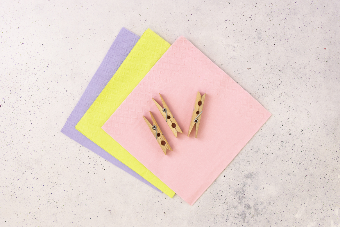 Bunte Papierservietten und Holzklammern