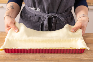 Blätterteig in Backform geben