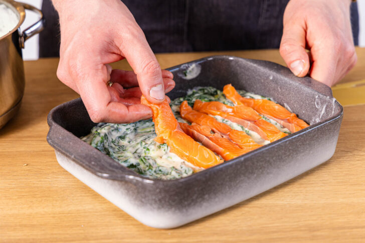 Lachs auf der Spinatsauce verteilen
