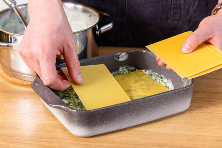 Lasagneblätter auf die Spinatsauce geben