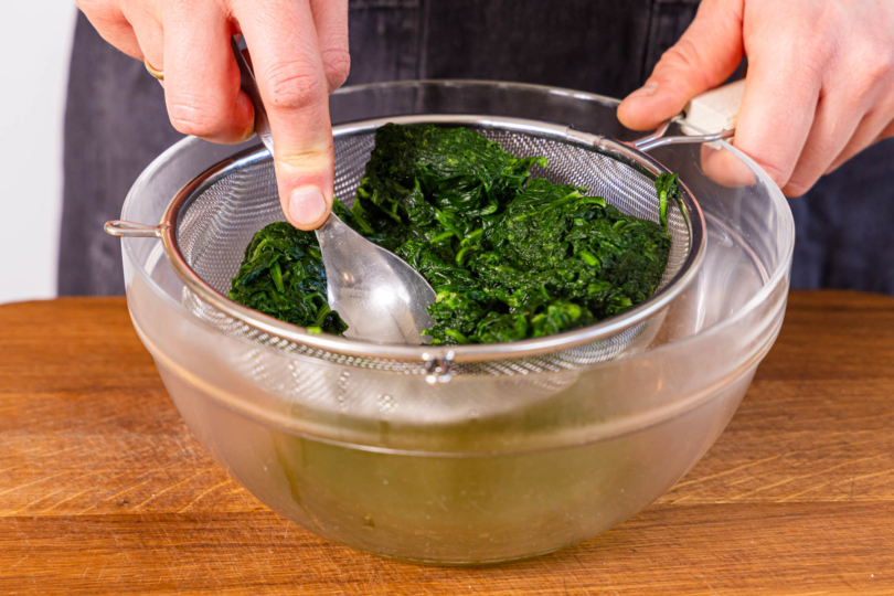 Lachs im Sieb über Schüssel ausdrücken