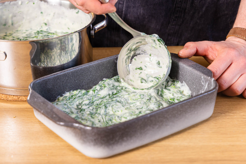 Spinatsauce in der Auflaufform verteilen