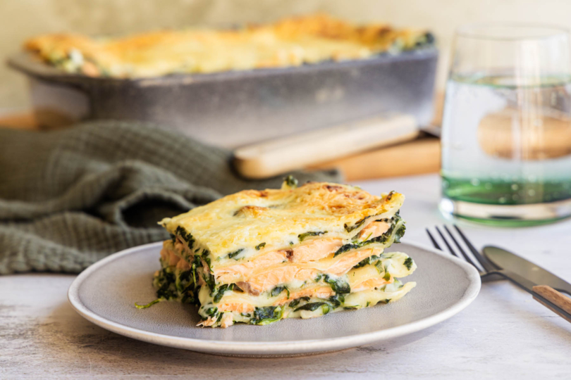 Stück Spinatlasagne mit Lachs auf einem Teller