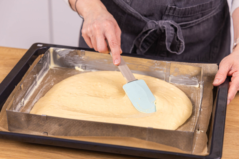 Teig auf Backblech im Rahmen verstreichen