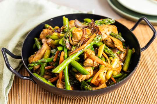 Asiatische Wok-Pfanne mit grünem Spargel und Hähnchen