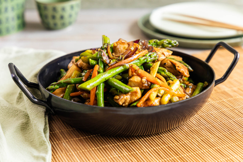 Asiatische Wok-Pfanne mit grünem Spargel und Hähnchen