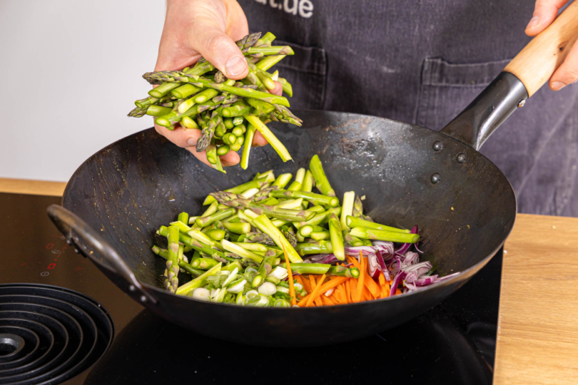 Gemüse in den Wok geben