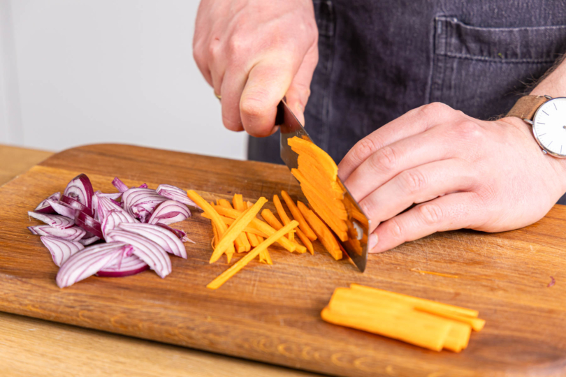 Zwiebel und Karotte in Streifen schneiden