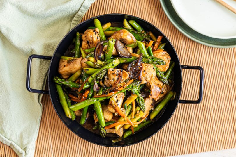 Asiatische Wok-Pfanne mit grünem Spargel und Hähnchen top-down
