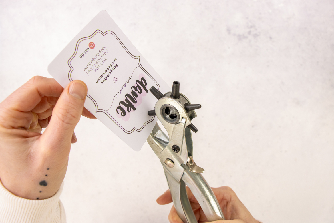 Etikett mit Lochzange lochen