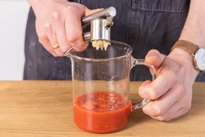 Knoblauch zu den gehackten Tomaten pressen