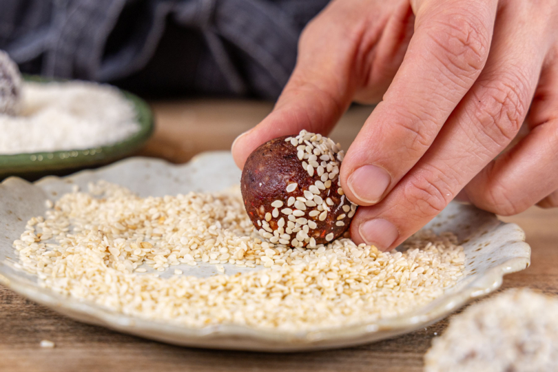 Energy Balls in Sesam wälzen