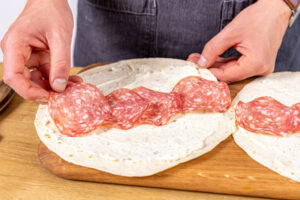 Salami auf Wrap platzieren