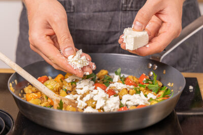 Feta in die Pfanne bröseln