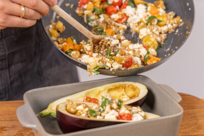 Gemüse-Feta-Füllung in die Aubergine geben