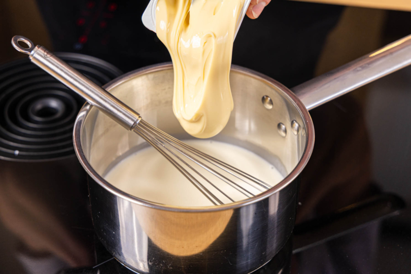 Schmelzkäse zur Milch und Sahne in den Topf geben