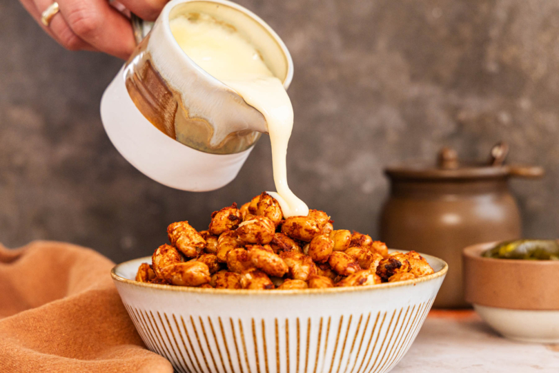 Käsesauce auf die gebackenen Bohnen aus der Heißluftfritteuse geben