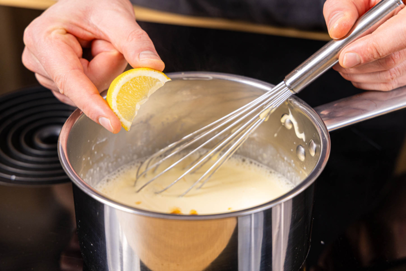 Käsesauce mit Zitronensaft würzen