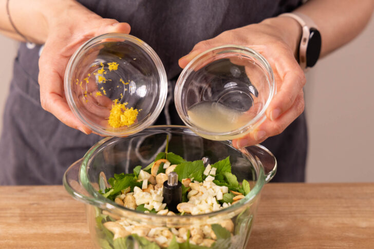 Zeste und Saft der Zitrone zu Pesto geben