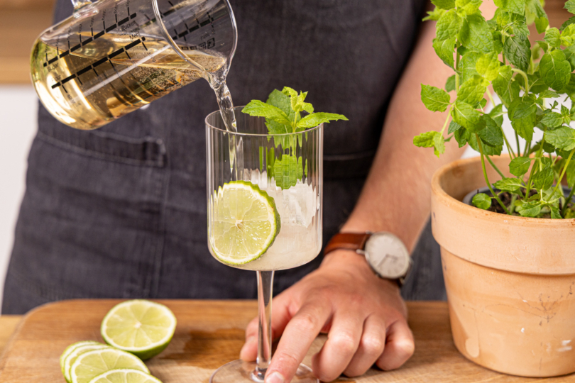 Glas mit alkoholfreiem Hugo aufgießen