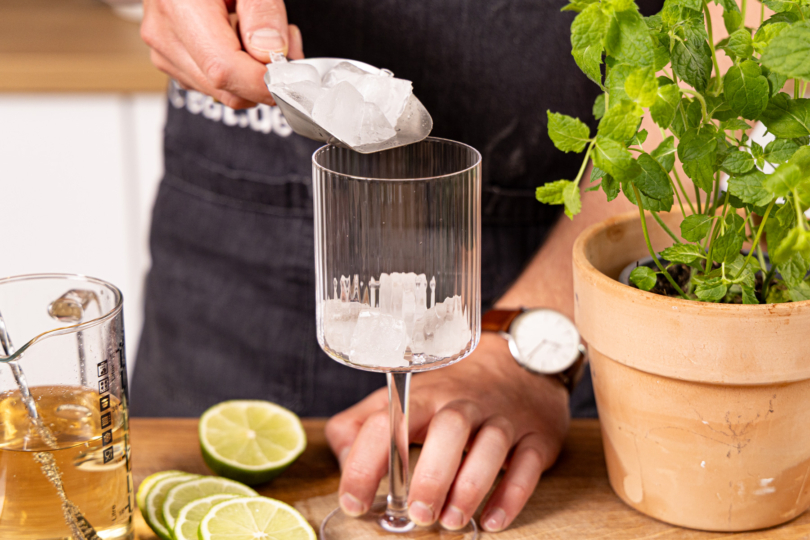 Eiswürfel ins Glas geben