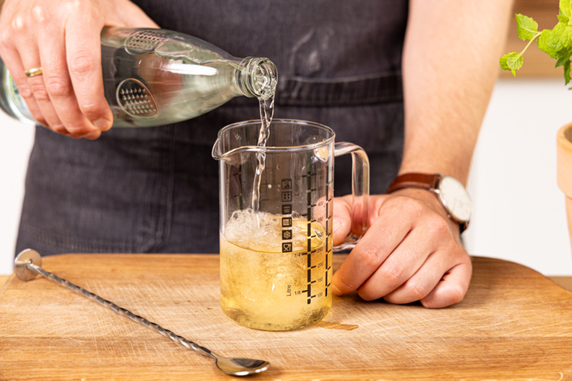 Mineralwasser in den Messbecher gießen