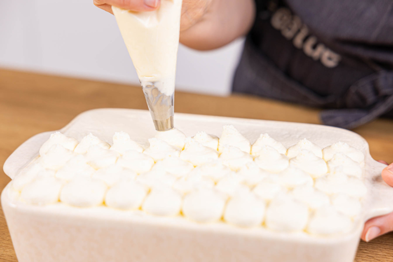 Cremetuffs auf das Kinder-Tiramisu spritzen