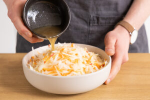 Dressing auf Salat geben