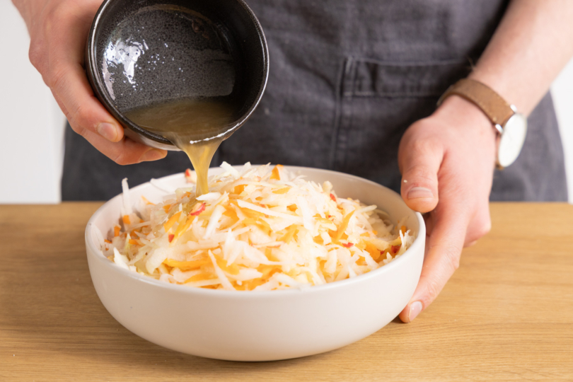 Dressing auf Salat geben