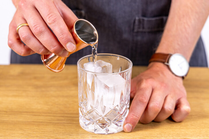 Gin ins Glas gießen
